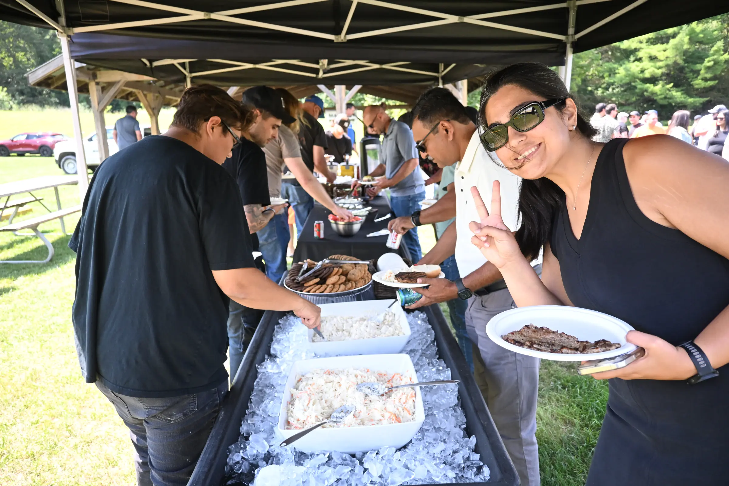 Maystar team members picking food from the buffet setup at the BBQ.